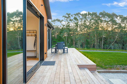 The deck runs the length of the front of the house and overlooks the lush fields.