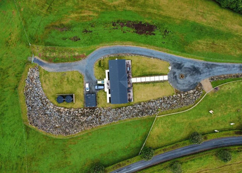 The aerial view of the home with surrounding land.