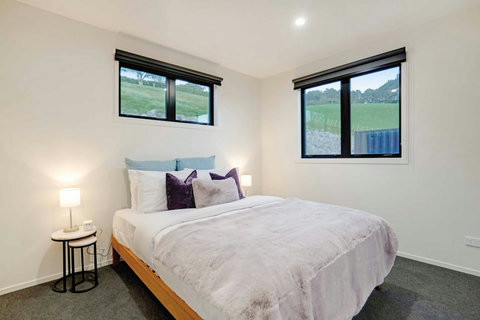 There are crisp white sheets and a fluffy throw on this Queen-sized bed.