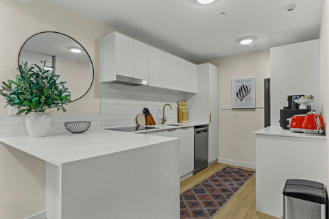 The kitchen has a cooktop, oven, dishwasher, microwave and fridge/freezer.