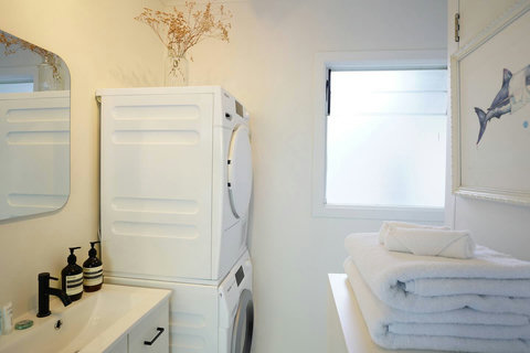 The washer and dryer are located in the bathroom.