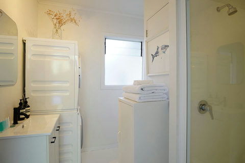 The bathroom has a toilet, shower and vanity unit.