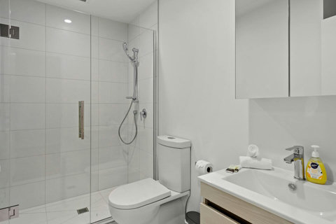The bathroom has a glass shower, toilet and vanity unit.