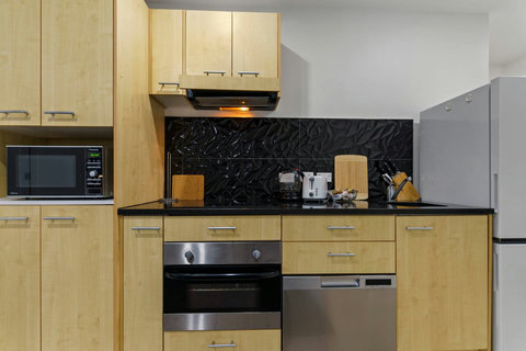 The kitchen has an oven, cooktop, dishdrawer, microwave and fridge/freezer.
