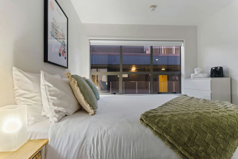 The bed looks inviting with its crisp white sheets and fluffy throw.