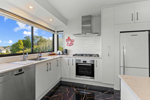 The kitchen has an oven, cooktop, dishwasher, microwave and fridge/freezer.