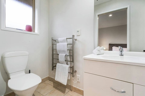 The ensuite bathroom has a shower, toilet, vanity and heated towel rail.