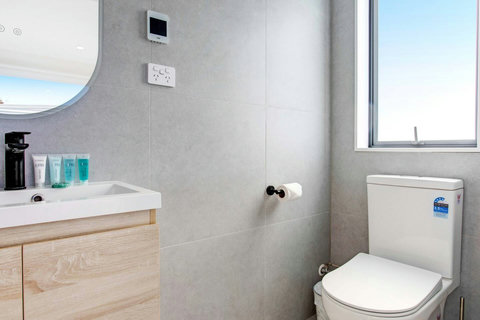 The ensuite bathroom has a shower, vanity and toilet.