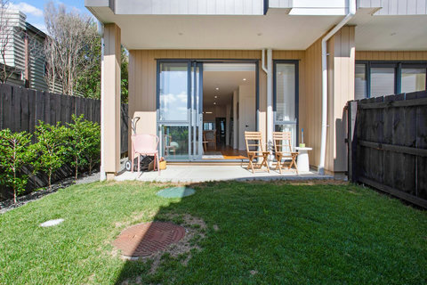The backyard is fenced with some outdoor furniture for those sunny days.