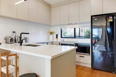 The kitchen has a dishwasher, fridge/freezer, cooktop, microwave and oven.