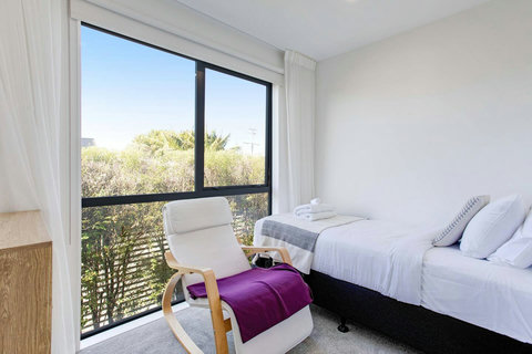 The chair in the room is a great place to read a book in the natural light.