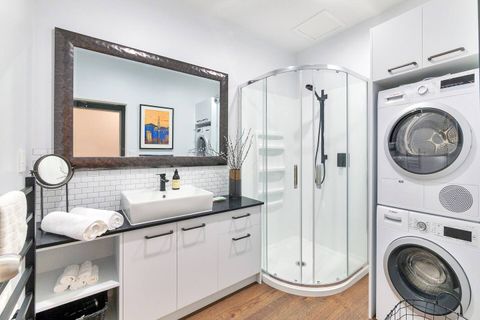 The bathroom has a glass shower, vanity and toilet.