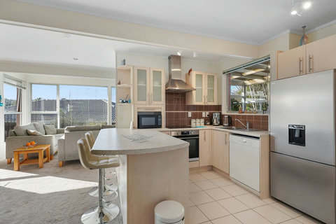 The kitchen has a cook top, oven, dishwasher, microwave, and large fridge/freezer.