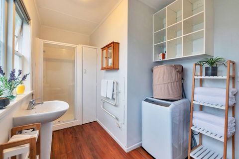 The bathroom has a shower, basin sink, toilet and heated towel rail. The washing machine is also in the bathroom area.