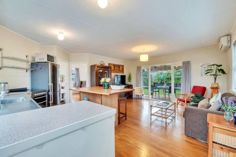 The open-plan living spaces include the kitchen, casual seating at the breakfast bar, and living room.