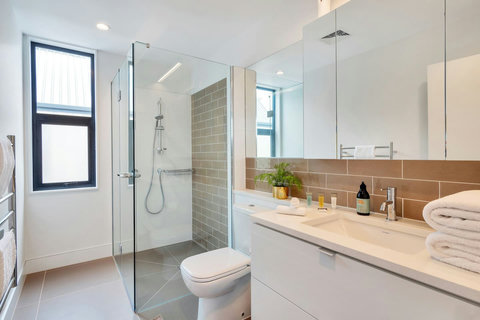 The ensuite bathroom has a shower, toilet, large sink and vanity unit.