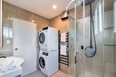 The bathroom has a convenient front loading washing machine and dryer.
