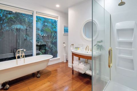 Large family-size bathroom with a claw-foot bath, separate shower and wooden vanity unit.