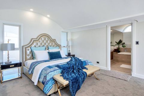 The blue bedroom resembles a luxury hotel suite with an ensuite bathroom, walk-in wardrobe and sitting room area.