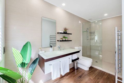 The mauve suite ensuite bathroom features a large walk-in shower, polished wooden floors, vanity and toilet.