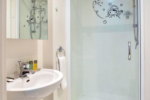 The bathroom has a shower, vanity and toilet.