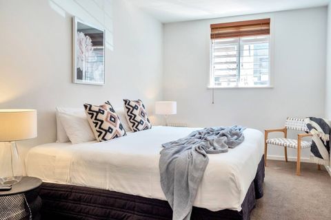 The bedroom has artwork, cushions, and throws that complement each other.