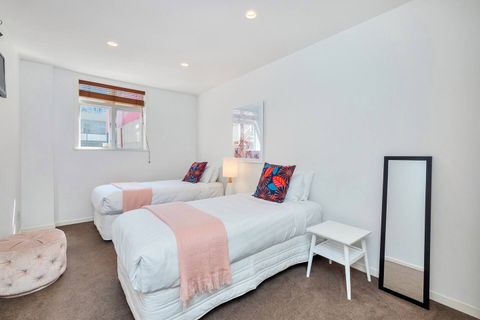 The second bedroom has two generous single beds and more than enough space for guests.