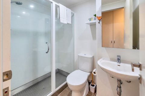 The bathroom has a large spacious shower with a toilet and mirror/vanity unit.