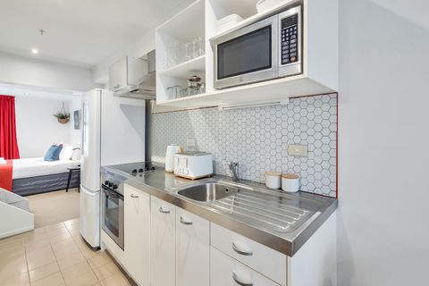 The compact kitchen has a glass cooktop, oven, microwave, and fridge/freezer.