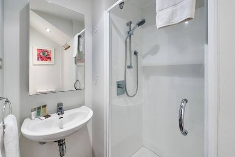 This bathroom also has a shower, vanity/mirror and toilet.