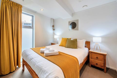 The upstairs bedroom has a Queen sized bed, bedside tables and modern lamps.