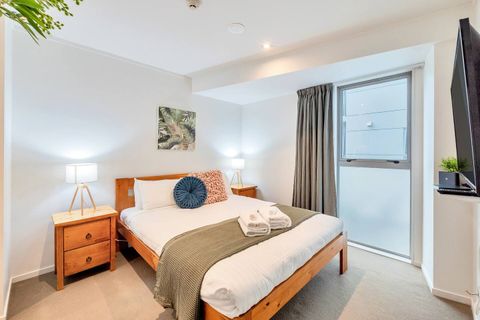 The upstairs bedroom has a queen-size bed, two bedside tables, and modern lamps.