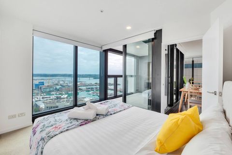 Bedroom one has a sea view of the Viaduct and the Auckland Harbour Bridge. This queen-size bed has an entry onto the balcony of the apartment.