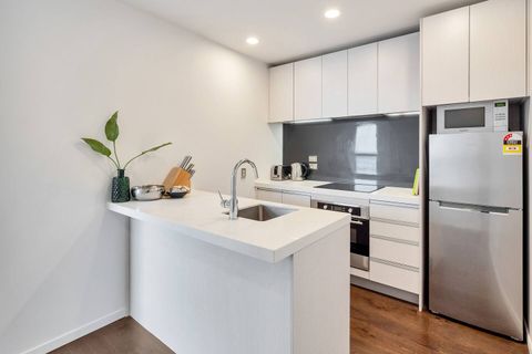 This modern kitchen comes with everything you need. This kitchen is separated from the rest of the open-plan living area with a marble-topped island bench. It also comes with a built-i oven, glass top hobs, fridge/freezer, microwave, and dishwasher.