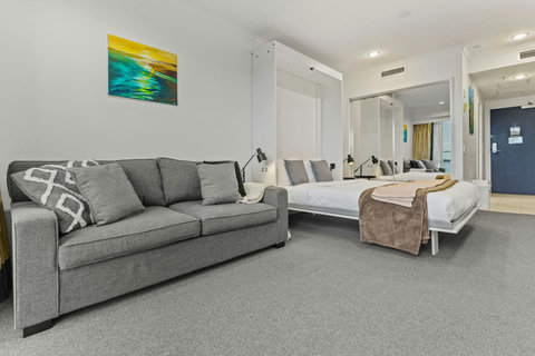 The apartment is a studio unit meaning the main bed is in the open plan area with the kitchen, couch and dining table.