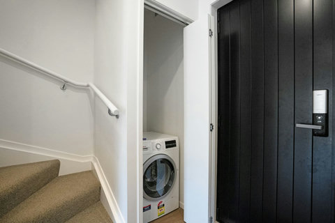 The combo washing machine and dryer are in the cupboard by the front door.