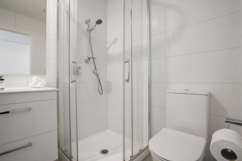 This ensuite bathroom has a vanity with large drawers, shower box and toilet.