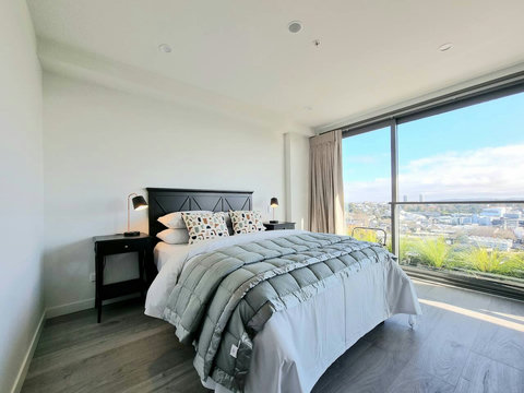 The main bedroom has floor-to-ceiling windows, a large double wardrobe, and an ensuite bathroom.