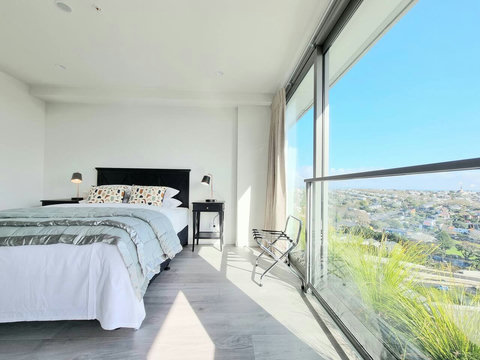 The bed invites you to rest and relax with its crisp white sheets and soft pops of colour.