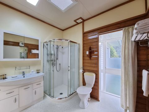 This bathroom features a modern glass shower, a large vanity unit and a toilet.