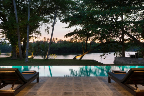 A serene poolside view overlooking the river.
Relax under the shaded veranda with uninterrupted views of the infinity-style pool, lush trees, and calm river—perfect for peaceful mornings or sunset moments.