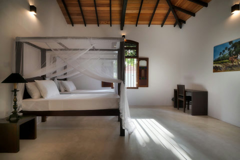 A spacious bedroom with two elegant canopy beds.