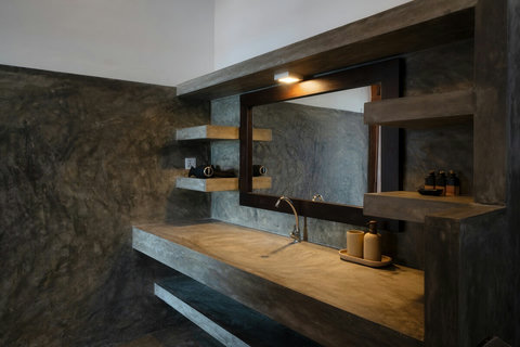 Stylish ensuite bathrooms with modern amenities.- All polished cement ensuites features an open shower, spacious vanity, and warm lighting. Guests are provided with fresh towels, shampoo, conditioner, body wash, and a hair dryer for added comfort.