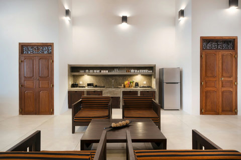 Kitchenette + Seating Area- A clean, open kitchenette with modern appliances and wooden finishes, seamlessly connected to the cosy living space.