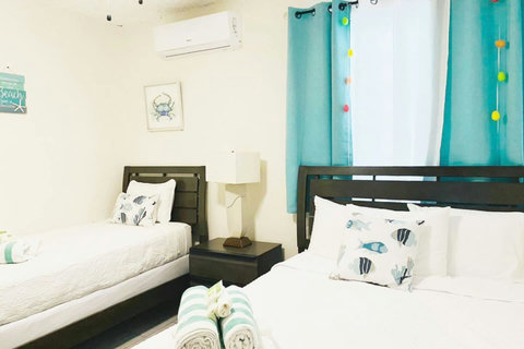 First Floor Bedroom 2: Bright space with playful decor, two comfy beds, and a beachy vibe!