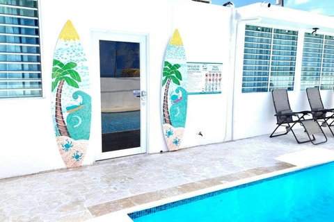 Poolside Retreat: Dive into relaxation by the vibrant surfboard decor and sparkling waters!