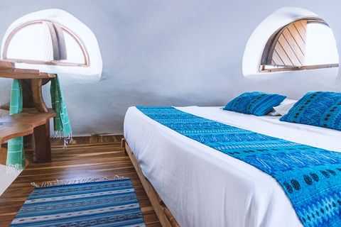 Queen bed and 3 port windows facing sunrise, the ocean and sunset