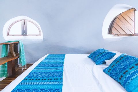 Queen bed and 3 port windows facing sunrise, the ocean and sunset