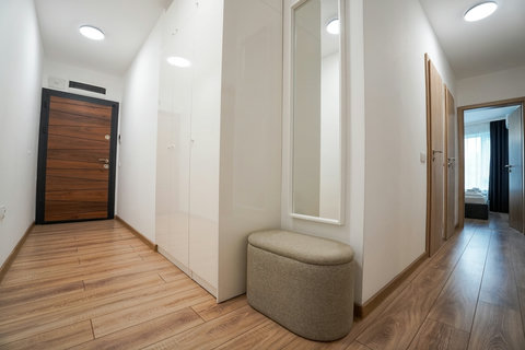 Bright modern entryway with built-in storage, mirror, and bench