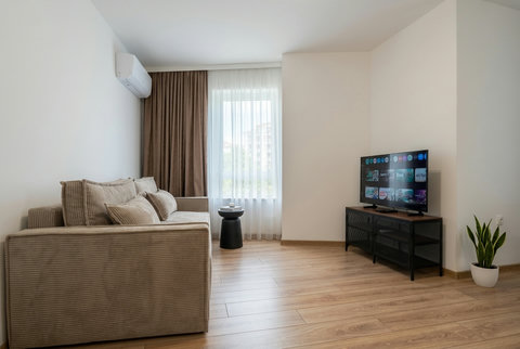 Bright minimalist lounge with smart TV, AC, and natural light